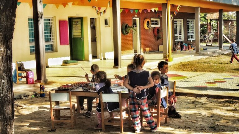 a group of children sitting around a table